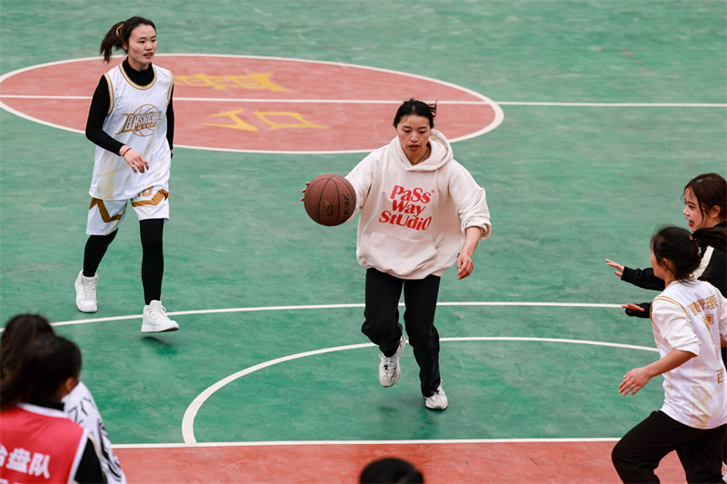 Έφηβοι παίζουν μπάσκετ στο χωριό Τάϊπαν, στην επαρχία Τάϊτζιανγκ, στην επαρχία Γκουέϊζοου της νοτιοδυτικής Κίνας, 25 Μαρτίου 2023. Η "Village Basketball Association" ή "Village BA", είναι ένα τουρνουά μπάσκετ βάσης που διεξάγεται στο χωριό Τάϊπαν. Η εκδήλωση αυτή, που διοργανώνεται από τους κατοίκους της περιοχής, έχει αποκτήσει δημοτικότητα με την πάροδο των ετών και προσελκύει μεγάλο πλήθος θεατών και συμμετεχόντων. Το τουρνουά αναδεικνύει το πάθος και τις δεξιότητες των παικτών μπάσκετ από αγροτικές περιοχές, καθώς ανταγωνίζονται και επιδεικνύουν την ομαδική τους εργασία στο γήπεδο. (Φωτογραφία / Xinhua)