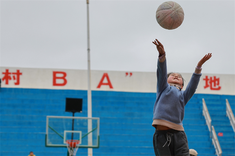 Ένα παιδί παίζει μπάσκετ στο χωριό Τάϊπαν, στην επαρχία Τάϊτζιανγκ, στην επαρχία Γκουέϊζοου της νοτιοδυτικής Κίνας, στις 25 Μαρτίου του 2023. (Φωτογραφία / Xinhua)