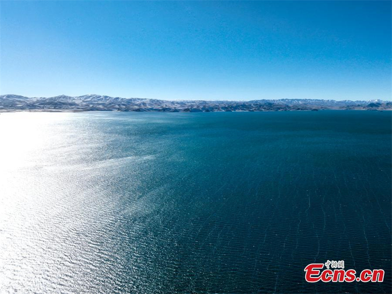 Χειμερινό τοπίο σαν ζωγραφιά της μισοπαγωμένης λίμνης Ντονγκτζί Τσουονά με γαλαζοπράσινα νερά στην κομητεία Μαντούο, της Αυτόνομης Νομαρχίας Γκολόγκ που βρίσκεται στην επαρχία Τσινγκχάι της βορειοδυτικής Κίνας. (Φωτογραφία: China News Service/Zhao Linsong)