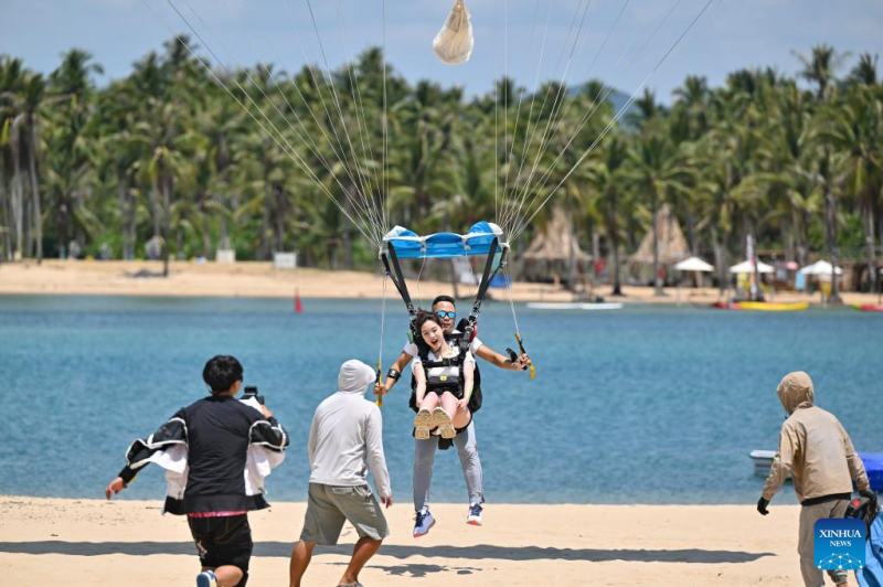 Ένας τουρίστας δοκιμάζει αλεξίπτωτο πλαγιάς στο Σάνγια, στην επαρχία Χαϊνάν της Νότιας Κίνας, 2 Μαΐου 2025. (Φωτογραφία / Xinhua)