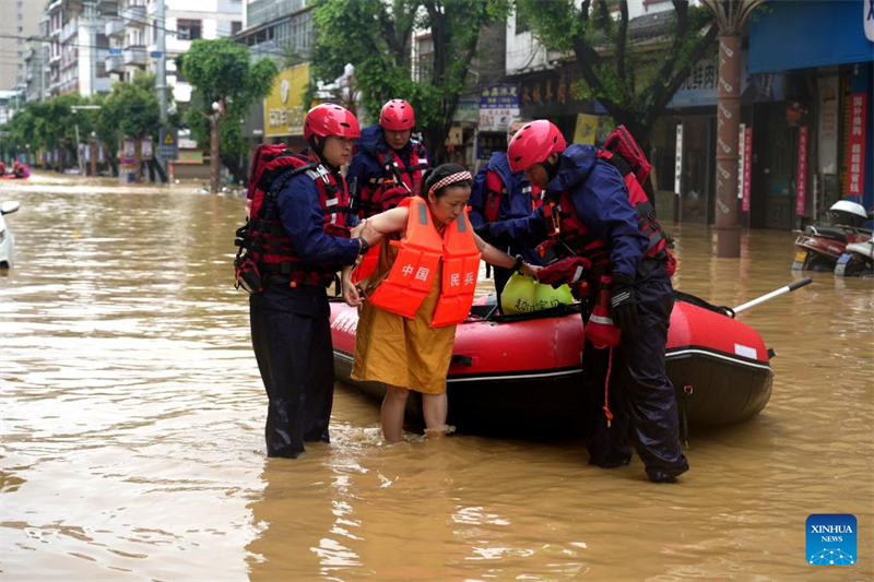 Διασώστες απομακρύνουν κατοίκους από την πληγείσα από τις πλημμύρες περιοχή στην κομητεία Ρονγκτζιάνγκ, της επαρχίας Γκουεϊτζόου, στις 25 Ιουνίου του 2025. (Φωτογραφία / Xinhua)