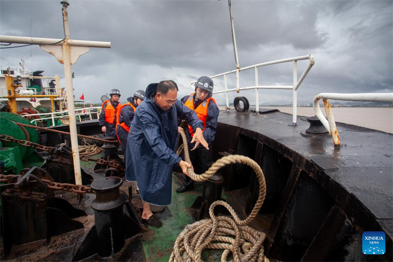 Αστυνομικοί εργάζονται μαζί με μέλη του πληρώματος για να ασφαλίσουν ένα σκάφος αγκυροβολημένο στην προβλήτα Σαντζιανγκόου (Sanjiangkou) στην πόλη Ταϊτζόου της επαρχίας Τζετζιάνγκ, στις 7 Ιουλίου του 2025. (Φωτογραφία / Xinhua)