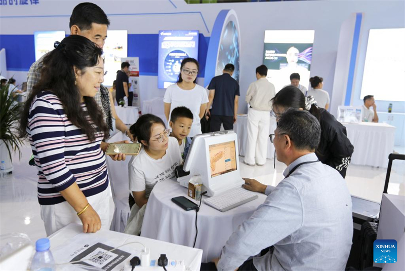 Επισκέπτες βιώνουν υπηρεσίες υγειονομικής περίθαλψης παραδοσιακής κινεζικής ιατρικής (TCM) με τη βοήθεια τεχνητής νοημοσύνης κατά τη διάρκεια της 6ης Έκθεσης Βιομηχανίας Παραδοσιακής Κινεζικής Ιατρικής (Traditional Chinese Medicine, TCM) της Κίνας (Γκανσού) ξεκίνησε την Κυριακή στην πόλη Ντινγκσί (Dingxi) της επαρχίας Γκανσού, στις 24 Αυγούστου του 2025. (Φωτογραφία / Xinhua)