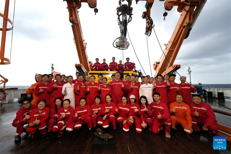 Τα μέλη της ερευνητικής αποστολής του πλοίου Τζονγκσάν Ντάσουε ποζάρουν για μια ομαδική φωτογραφία με το αυτο-αναπτυγμένο κινεζικό Χαϊτσίν, ένα τηλεχειριζόμενο όχημα (Remotely Operated Vehicle, ROV) βαθιάς θάλασσας 6.000 μέτρων, στο πλοίο Τζονγκσάν Ντάσουε, στη Θάλασσα της Νότιας Κίνας, στις 23 Αυγούστου του 2025. (Φωτογραφία / Xinhua)