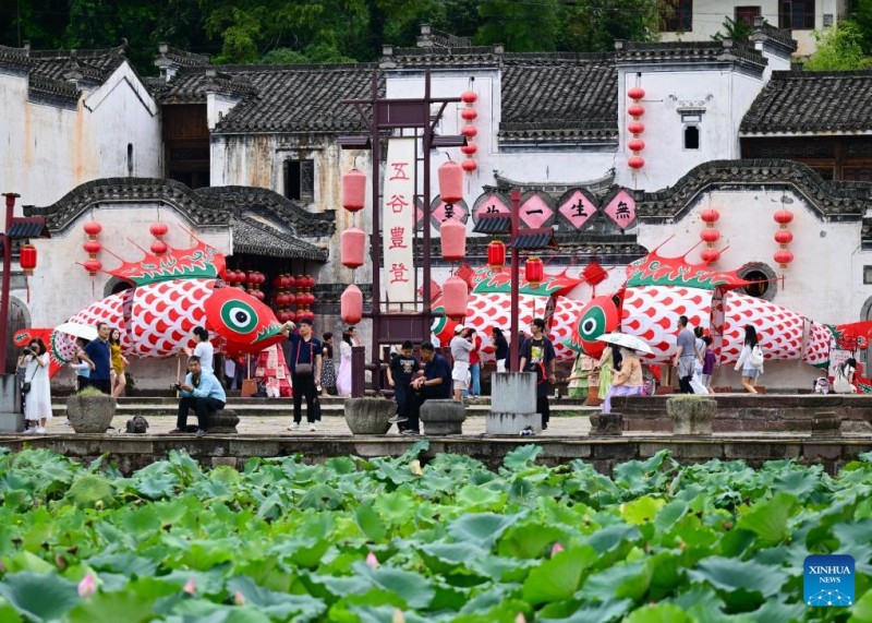 Τουρίστες παρακολουθούν τα φανάρια σε σχήμα ψαριού στο χωριό Τσενγκκάν, της επαρχίας Ανχουέι, στις 21 Αυγούστου του 2025. 