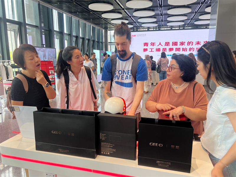 Δημοσιογράφοι παρακολουθούν ένα ανθρωποειδές ρομπότ που μεταφέρει ένα κουτί στο Κέντρο Καινοτομίας και Επιχειρηματικότητας για νέους μεταξύ της πόλης Σεντζέν και του Χονγκ Κονγκ στην περιοχή Τσιενχάι, στις 15 Σεπτεμβρίου του 2025. (Φωτογραφία / Λαϊκή Καθημερινή Online)