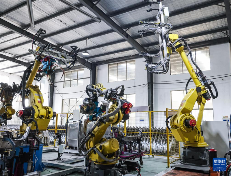 Μέσα σε ένα εργαστήριο παραγωγής στην πόλη Τζινχουά, αυτοματοποιημένα μηχανήματα επεξεργάζονται εξαρτήματα για οχήματα νέας ενέργειας. (Φωτογραφία / Xinhua)