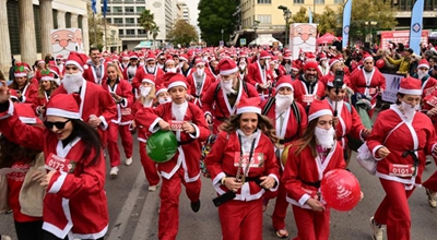 Άνθρωποι συμμετέχουν στο Athens Santa Run 2025 στην Αθήνα